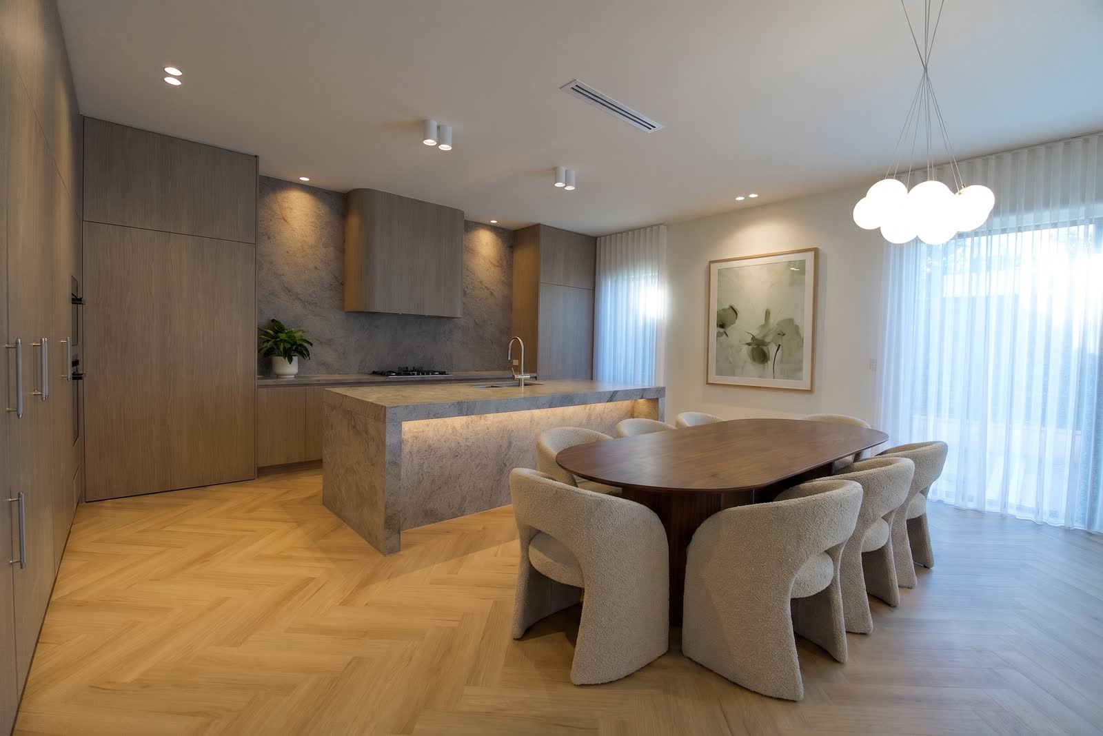 The kitchen and dining room of 5A, herringbone floor and stone island
