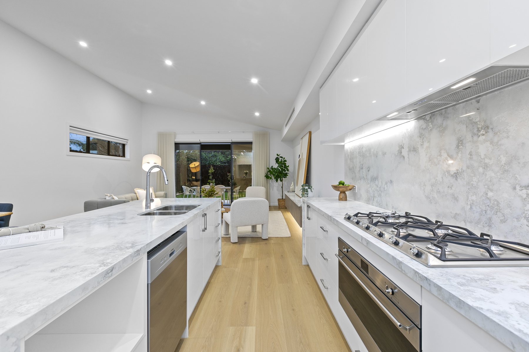 Kitchen with gas cooktop and stone splashback
